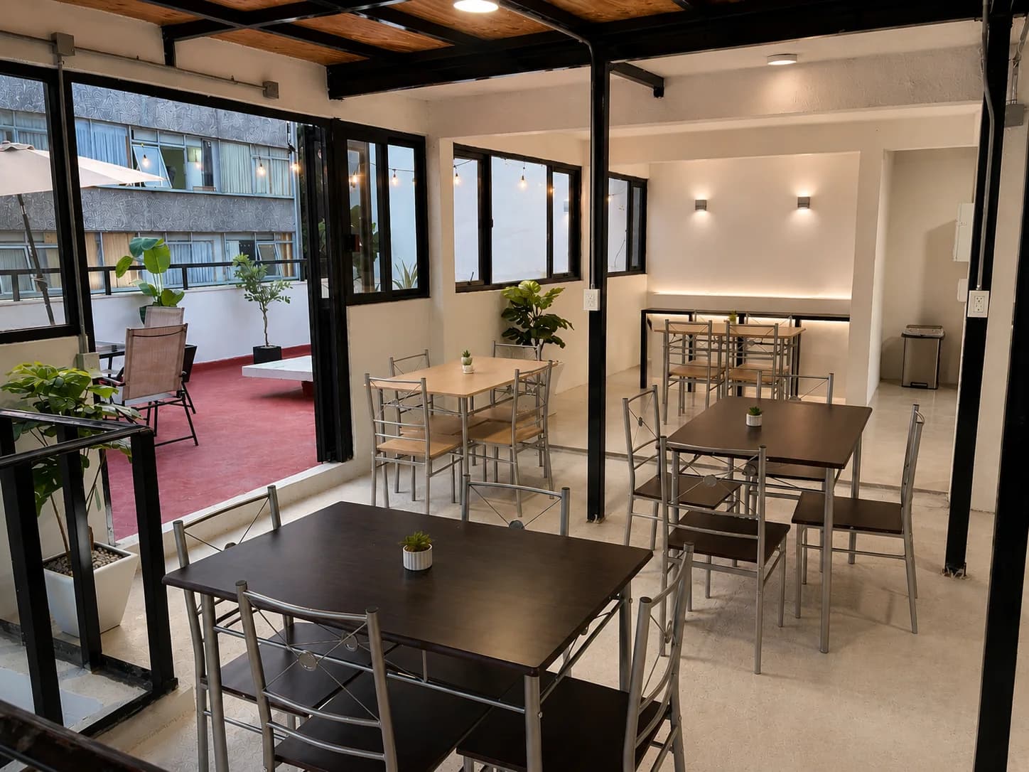 Comedor de Vibe Living con mesas compartidas y salida a la terraza