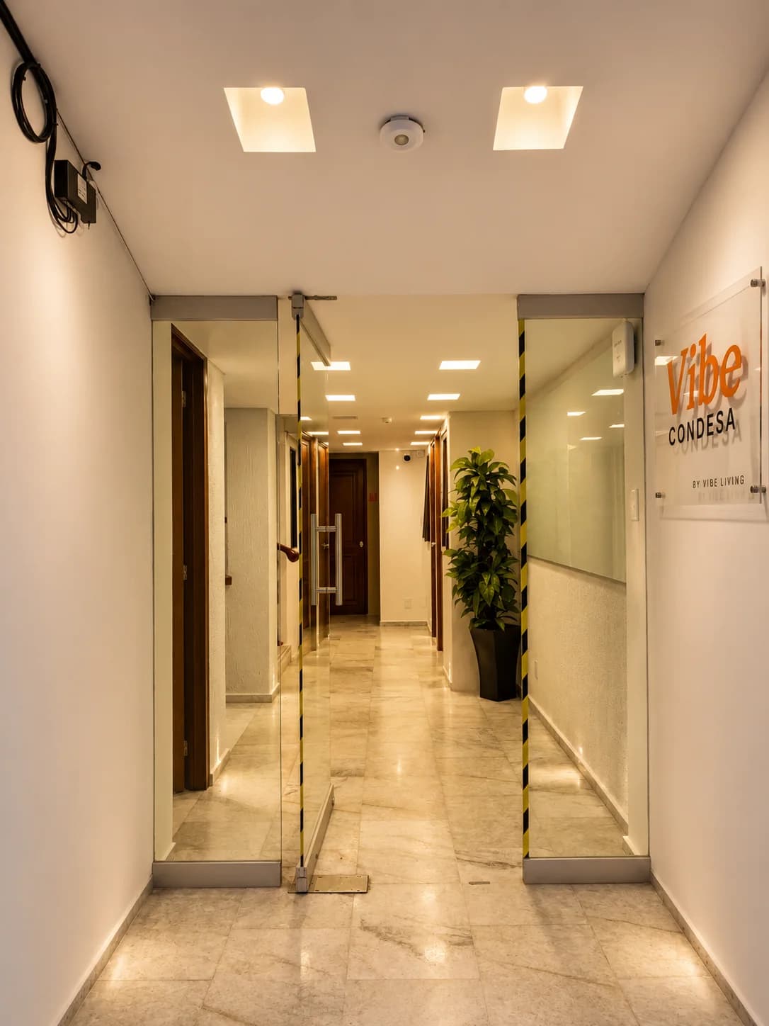 Entrada de Vibe Living — recibidor de mármol con acceso controlado