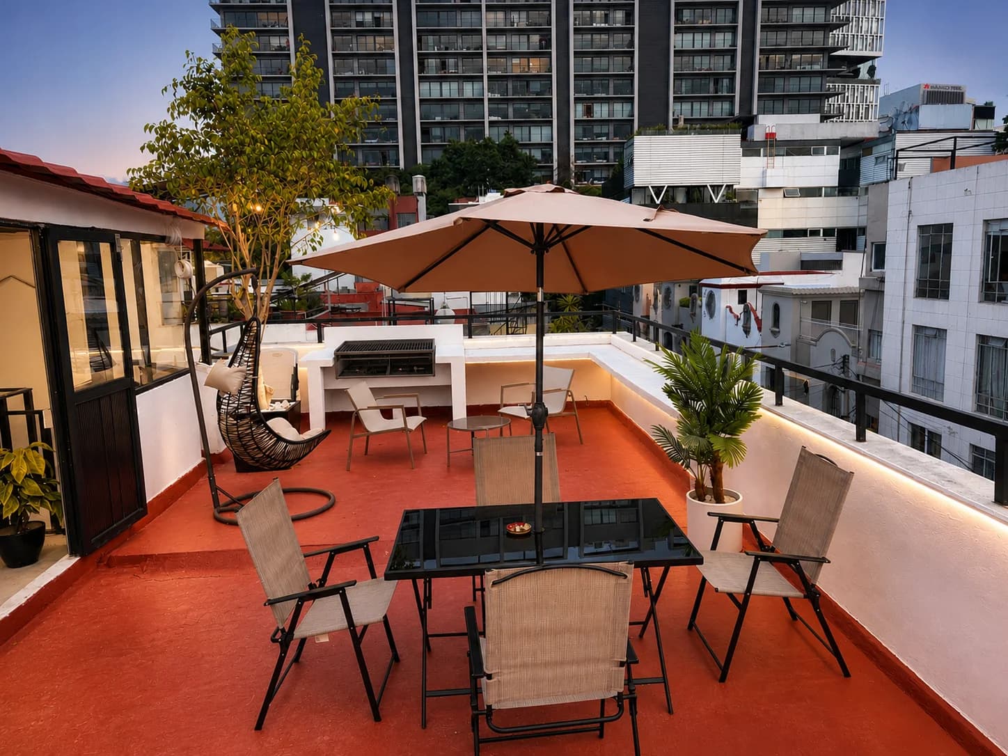 Terraza del rooftop con asador, sombrilla y silla colgante — Vibe Living